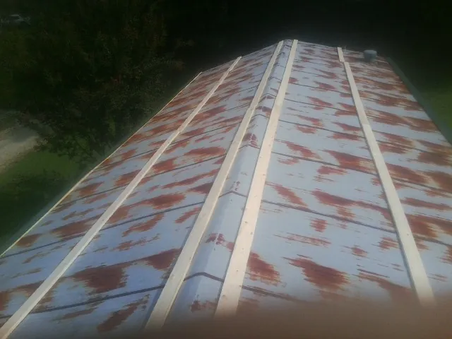 Rusted metal roof panels with new wood purlins before replacement — Storm Damage Roof Repair in Garwin by Roofing Brothers