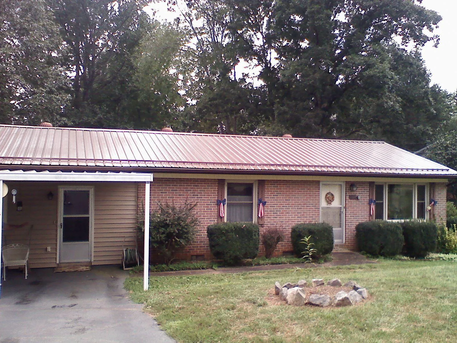Bronze metal roof and carport on a brick ranch home — Roof Repair work by our crew in Garwin
